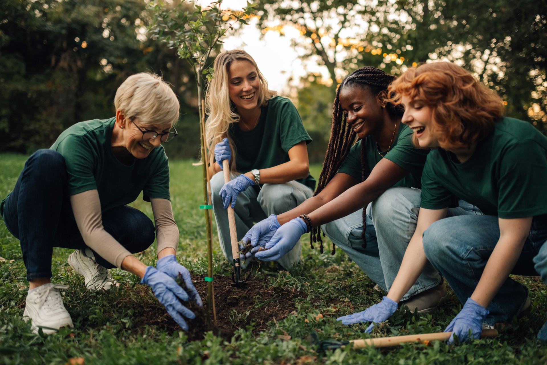 Group of volunteers planting new tree in park